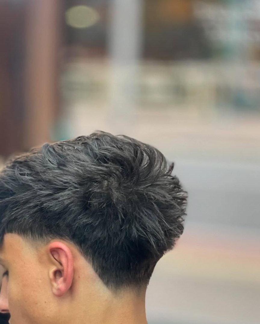 The side of a low fade, blended from short at the ear up into the length on top with no visible step