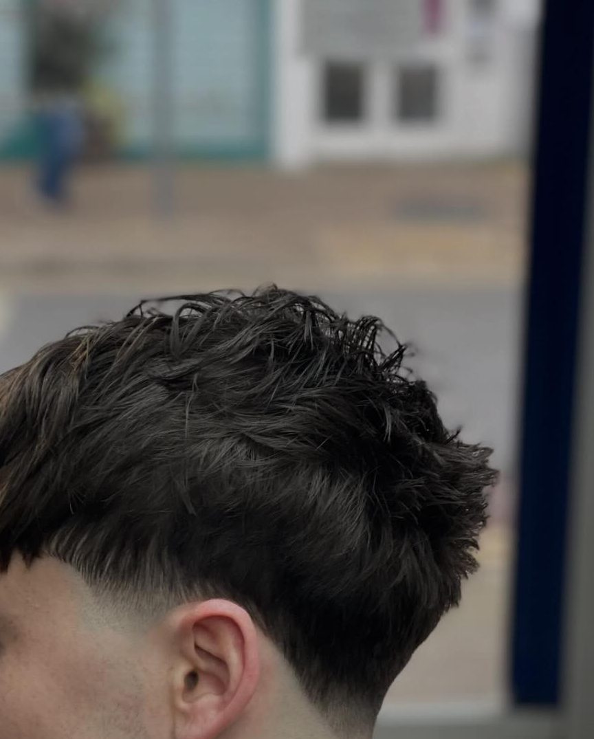 The back and side of a taper, cut close behind the ear and blended up into the length left on top